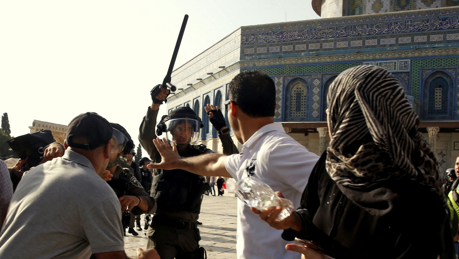Un policier israélien lève sa matraque sur les fidèles Palestiniens près de la mosquée Al Aqsa dans la vieille ville de Jérusalem, le 27 juillet 2017. Mahmoud Illean / AP 